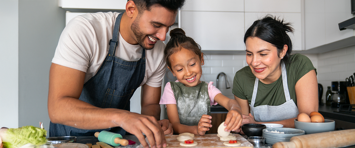 A family cooking together in a kitchen.
