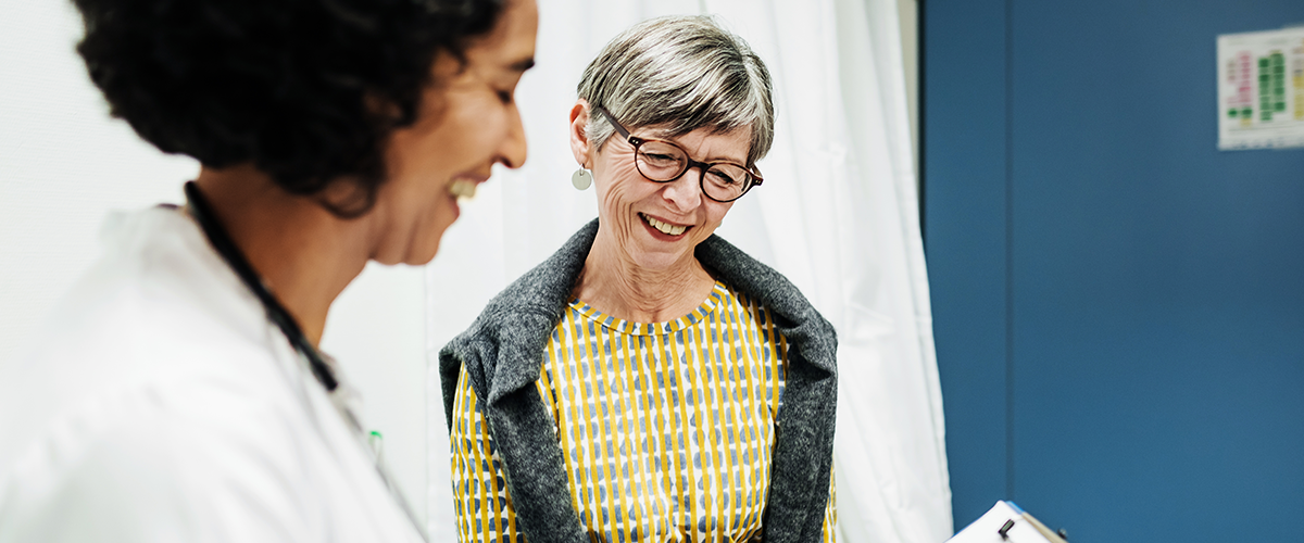 An older woman, speaking with a physican, looking over results together.